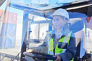 Asian woman, logistics and machine for industry shipping at work for transportation in container yard. An engineer