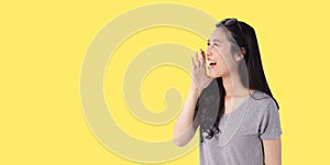 Asian woman with long black hair There is a beautiful smile shouting and gaping on a light yellow isolated background