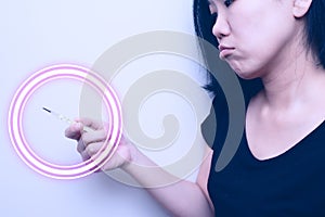 Asian woman looking at  clinical thermometer on her hand for checking temperature. With anxiety mood. with circle wave on