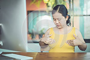 Asian woman looking her breast and feeling concern after checking breast by herself that risky to cancer