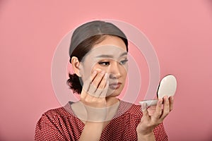 Asian woman looking at her facial problem in the mirror, Female feeling annoy about her reflection appearance show the aging skin.