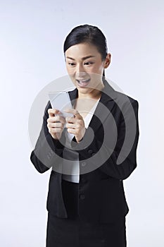 An Asian woman looking at her mobile phone very gladly. Business ideas, job applications, good news, selection, finalists photo
