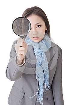 Asian woman looking through a magnifying