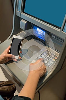 Asian woman looking at mobile phone display while pressing digit