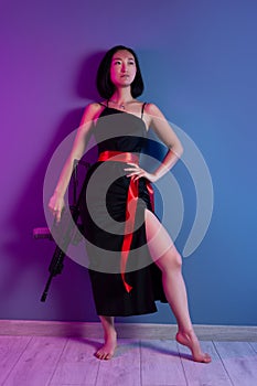 asian woman with a machine gun aims for shooting