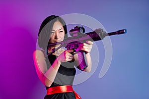 asian woman with a machine gun aims for shooting