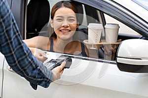 Asian woman making contactless payment with credit card for coffee