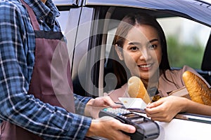 Asian woman making contactless payment for grocery