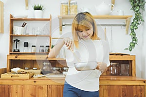 Asian woman making healthy food standing happy smiling in kitchen preparing salad.