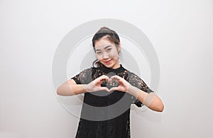 Asian woman making a heart sign with her hands, body language