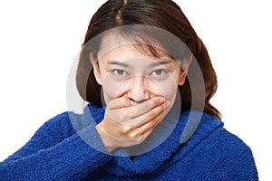 Asian woman making the speak no evil gesture