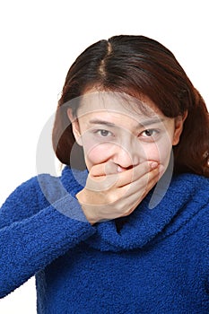 Asian woman making the speak no evil gesture