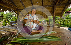 Asian woman making straw mats