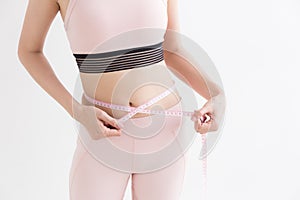 Asian woman with measure tape in her hand to measure herself,Healthy lifestyles concept of body