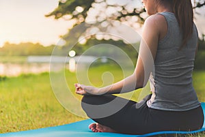 Asian woman meditating and sit in the lotus pose at park, Healthy and Yoga Concept,Mind-body improvements concept, Selective focus