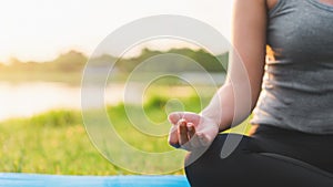 Asian woman meditating and sit in the lotus pose at park, Healthy and Yoga Concept,Mind-body improvements concept, Selective focus