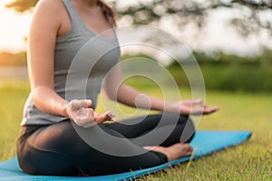 Asian woman meditating and sit in the lotus pose at park, Healthy and Yoga Concept,Mind-body improvements concept, Selective focus