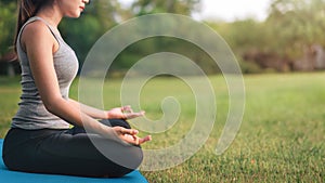 Asian woman meditating and sit in the lotus pose at park, Healthy and Yoga Concept,Mind-body improvements concept, Selective focus