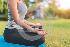 Asian woman meditating and sit in the lotus pose at park, Healthy and Yoga Concept,Mind-body improvements concept, Selective focus