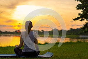 Asian woman meditating and sit at park, Healthy and Yoga Concept,Mind-body improvements concept, Selective focus, Copy space