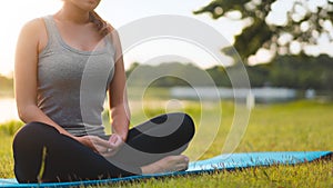 Asian woman meditating and sit at park, Healthy and Yoga Concept,Mind-body improvements concept, Selective focus, Copy space