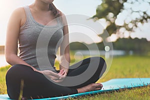 Asian woman meditating and sit at park, Healthy and Yoga Concept,Mind-body improvements concept, Selective focus, Copy space