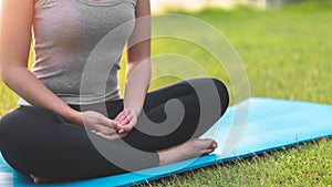 Asian woman meditating and sit at park, Healthy and Yoga Concept,Mind-body improvements concept, Selective focus, Copy space