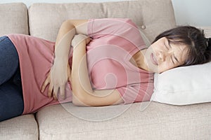 Asian woman with menstruation and pain period cramps. young women having painful stomachache