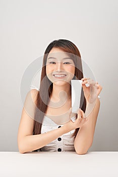 Asian woman model present showing cosmetic make up package products empty copy space on her hand palm