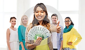 Asian woman with money showing thumbs up
