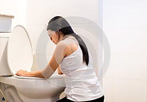 Asian woman with morning sickness,Pregnant female nausea into the toilet bowl