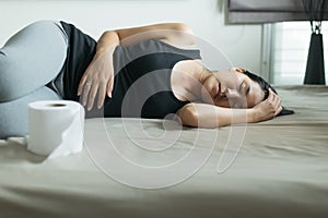 Asian woman with morning sickness and sleeping,Pregnant female nausea in bedroom,Indigestible