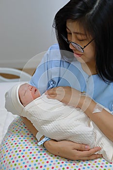 Asian woman mother holding and looking a little baby with feeling love