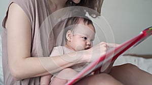 Asian woman mother parent reading storybook with baby infant. 3 months old kid learning development skill from mom with relationsh