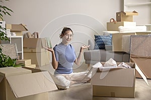 Asian woman moving to new home, smiling and looking at camera