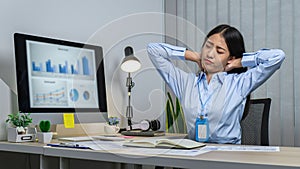 Asian woman office worker close eyes and raising hands to rest at back of head