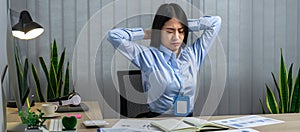 Asian woman office worker close eyes and raising hands to rest at back of head