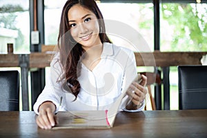 Asian woman open menu for ordering in coffee cafe and restaurant