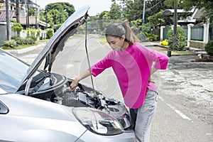 Asian woman opening car hood and looking for trouble car breaks down