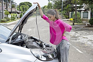 Asian woman opening car hood and looking for trouble car breaks down