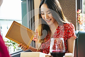 Asian woman opening present gift box on Valentine day