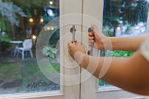 Asian woman opens a window to ventilate