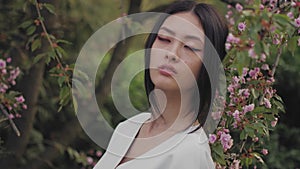 Asian woman outdoors on spring against flower blossom