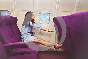 Asian woman passenger relaxing at the business class of airplane.