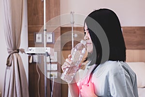 Asian woman patient having or symptomatic reflux acids at hospital,Gastroesophageal reflux disease,Drinking water