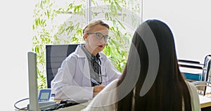 Asian woman patient sitting with doctor about her illness and showing x-ray results with blood pressure and heart rate measurement