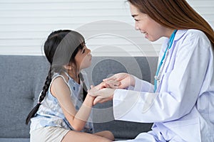 Asian woman pediatrician doctor hold stethoscope for exam a little girl patient and heck heart lungs of kid, Good family doctor