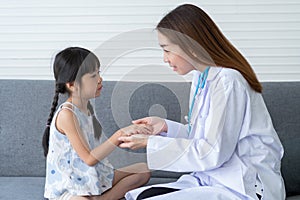 Asian woman pediatrician doctor hold stethoscope for exam a little girl patient and heck heart lungs of kid, Good family doctor