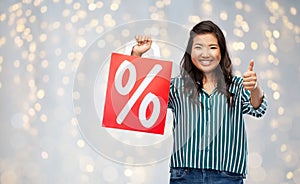 Asian woman with percentage sign on shopping bags