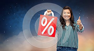 Asian woman with percentage sign on shopping bags